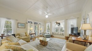 A spacious living room with a large sofa set, a coffee table, and a television. - Large Seaside Home, Tower w/ Gulf Views, Sleeps 12, 3 Min to Beach + 2 Bikes! (Santa Rosa Beach)