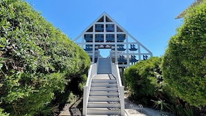 A staircase leading to a modern building with a triangular roof and multiple windows. - Large Seaside Home, Tower w/ Gulf Views, Sleeps 12, 3 Min to Beach + 2 Bikes! (Santa Rosa Beach)