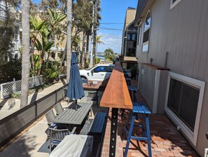 Relax on the patio surrounded by lush greenery and enjoy meals at the long table.