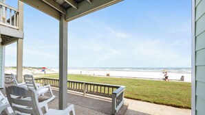 A covered patio with chairs overlooking a beach. - Gulf View Beachfront Escape | Pool, Hot Tub & Pet-Friendly (Corpus Christi)