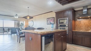A modern kitchen with granite countertops, stainless steel appliances, and dark wood cabinetry. - Sonoran Sky 308 Must-see Clean Bright Ocean View Condo (Puerto Peñasco)