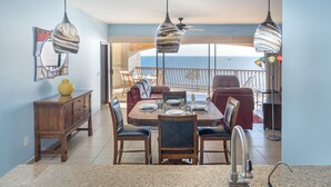 Un comedor con una mesa redonda, sillas y una cocina con un fregadero.