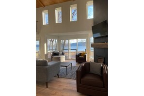 Relax in this stylish living room with a fireplace, flat-screen TV, and views of the water.