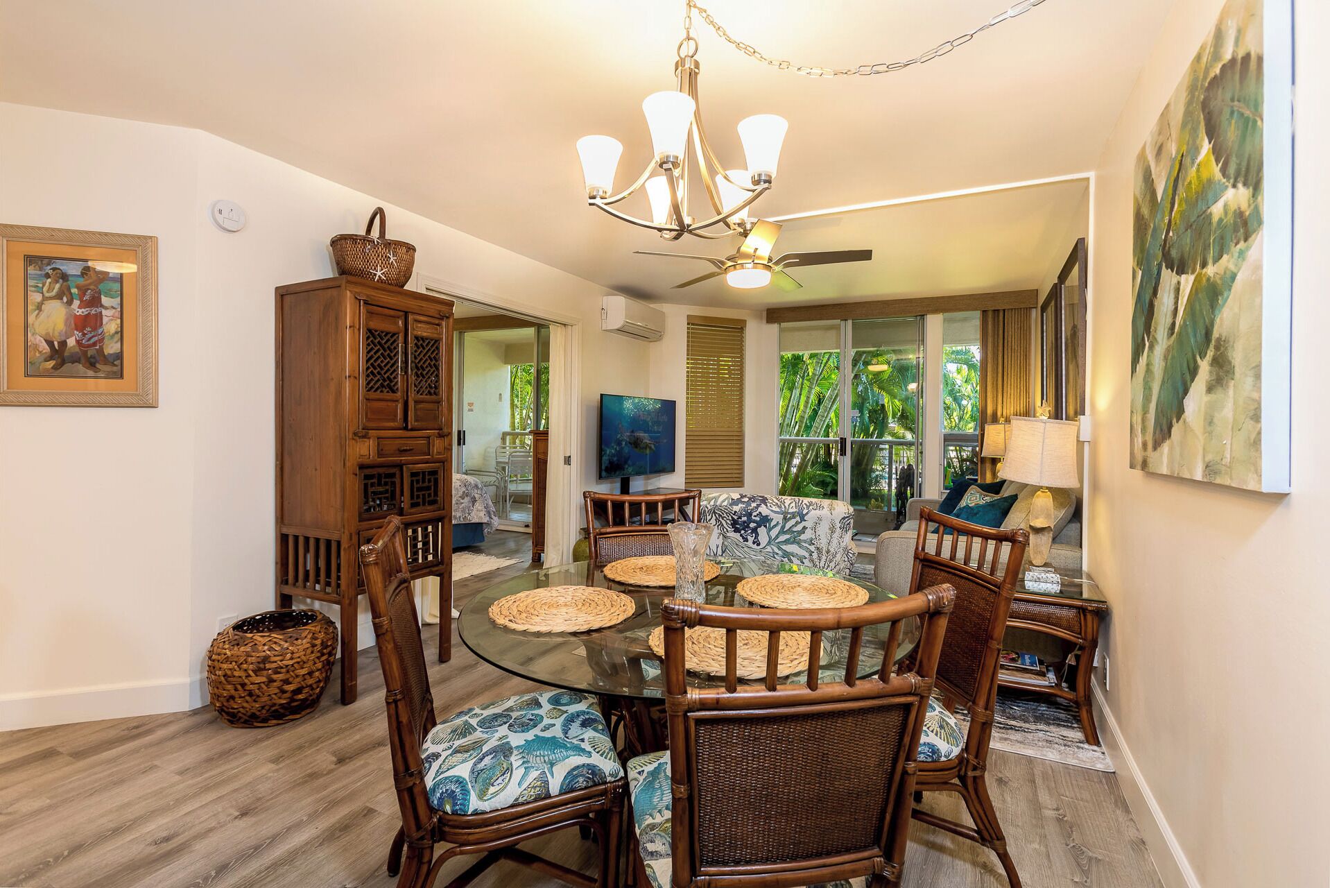 A dining area with a glass-top table, wicker chairs, and a ceiling fan.