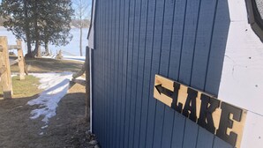 A wooden building with a sign indicating 'LAKE' and an arrow pointing to the left. - Silver Lake Cabin (Traverse City)