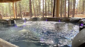 A hot tub with a wooden deck and a forest view. - Large Black Butte Home With Private Hot Tub (Sisters)