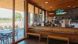 A restaurant with a wooden interior, large windows, and a bar area. - Large Black Butte Home With Private Hot Tub (Sisters)