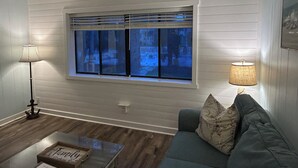 A living room with a window, a lamp, a sofa, and a coffee table.