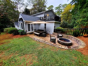 A two-story house with a covered patio, a fire pit, and outdoor furniture. - The Haymount Inn by Haymount Homes (Fayetteville)