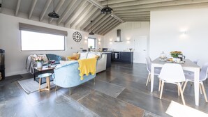 A modern kitchen with a central island, a dining area with a table and chairs, and a living area with a sofa and a coffee table. - Dorset Eco Retreats - Ansty, Dorchester (Ansty, Dorchester)