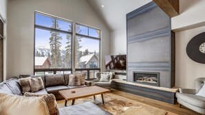 Ein geräumiges Wohnzimmer mit einem großen Ecksofa, einem Kamin und einem Fernseher.