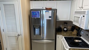A kitchen with stainless steel appliances, a water dispenser, a microwave, and a stove. - Great Weekly Rate With Beachfront Views (Panama City Beach)