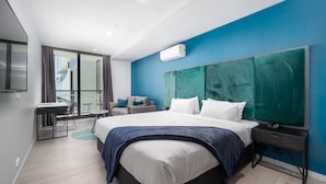 Ein modernes Hotelzimmer mit einem großen Bett, einem Schreibtisch und einem Balkon mit Blick.
