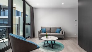 Ein modernes Wohnzimmer mit einer Couch, einem runden Couchtisch und einem Sessel.