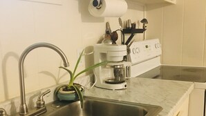 Eine Küche mit doppelter Spüle, einer Kaffeemaschine und einem Fenster mit Blick auf Bäume.