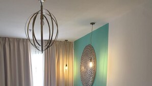 A hotel room with a bed, a sofa, a glass coffee table, and a decorative wall piece. - Dona Lola (Seville)
