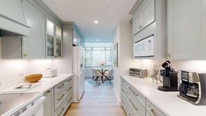 A modern kitchen with white cabinets, a microwave, a toaster, and a coffee maker. - Large Three Bedroom Villa Overlooking the George Fazio Golf Course! (Hilton Head)