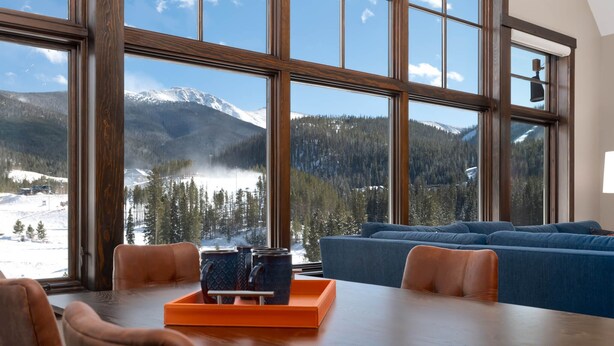 A dining area with a view of a snowy mountain landscape through large windows.