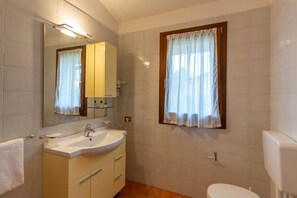 Een bad/douchecombinatie, een haardroger, een bidet, handdoeken