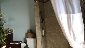 Un baño con ducha, inodoro y lavamanos.