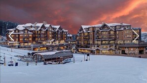 Un centro de esquí cubierto de nieve con varios edificios de alojamiento, remontes y un telesilla Super Chair.