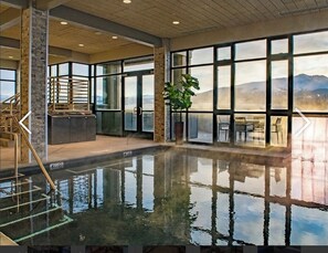 An indoor swimming pool with clear views of mountains through large windows. - True Ski-in Ski-out - 2BR, sleeps 8, ONLY New Year Week (Breckenridge)