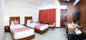 A hotel room with two beds, a desk with a TV, a chair, and a red curtain.