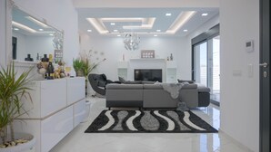 Un soggiorno moderno con divano, televisore e oggetti decorativi.