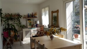 A dining area with a table, chairs, a hanging light fixture, and a window with a view of the outside. - Bed and breakfast, quiet area near Orange, Vaucluse (Sérignan-du-Comtat)
