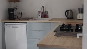 A modern kitchen with grey cabinets, a dishwasher, a stove, and a coffee maker. - Bed and breakfast, quiet area near Orange, Vaucluse (Sérignan-du-Comtat)