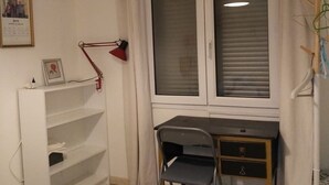 A room with a desk, chair, and a window with curtains. There is a shelf with a framed picture and a lamp on the desk. - Bed and breakfast, quiet area near Orange, Vaucluse (Sérignan-du-Comtat)