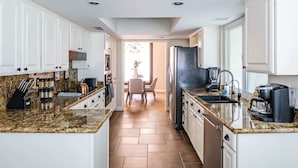 A modern kitchen with white cabinets, granite countertops, and a central island. - Elegance & Class - Centrally located Scottsdale home with heated* pool & fire-pit (Scottsdale)