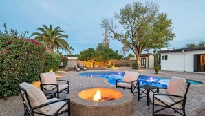 A backyard with a fire pit, outdoor seating, a swimming pool, and a house. - Elegance & Class - Centrally located Scottsdale home with heated* pool & fire-pit (Scottsdale)