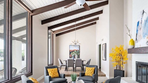 A spacious living room with a high ceiling, large windows, and a fireplace. - Elegance & Class - Centrally located Scottsdale home with heated* pool & fire-pit (Scottsdale)
