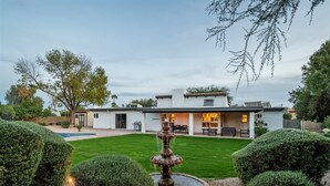 A modern house with a well-manicured lawn, a fountain, and a pool. - Elegance & Class - Centrally located Scottsdale home with heated* pool & fire-pit (Scottsdale)
