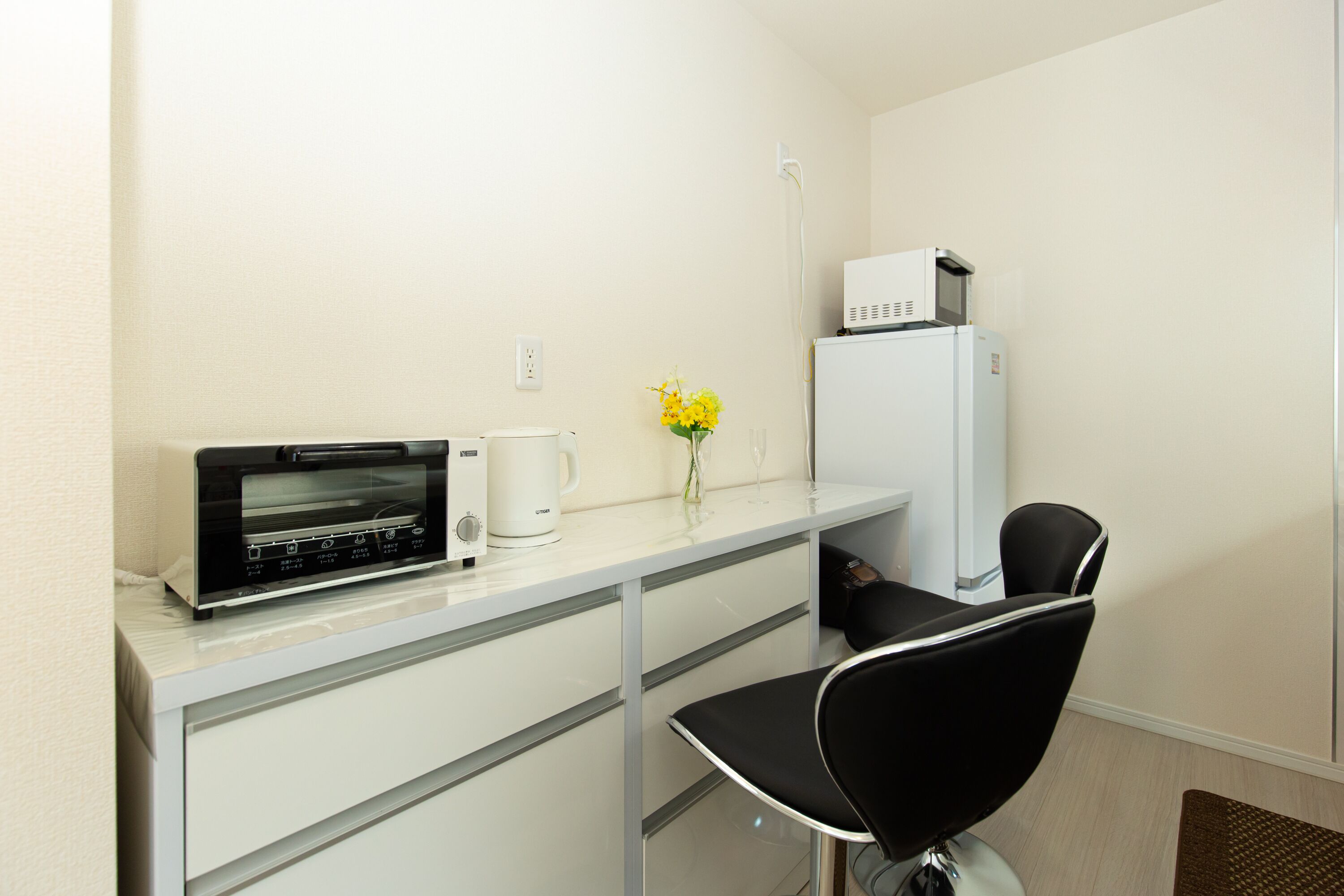 A compact kitchenette with a microwave, coffee maker, and refrigerator.