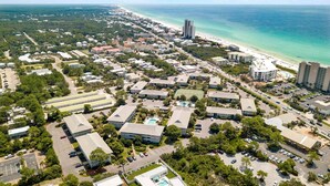 Luchtbeeld van een kustplaats met woongebouwen, een strand en een groot hotel met zwembad.