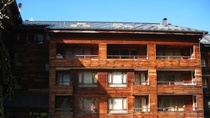 Un immeuble en bois à plusieurs étages, doté de balcons, de grandes fenêtres et d’un toit en pente.