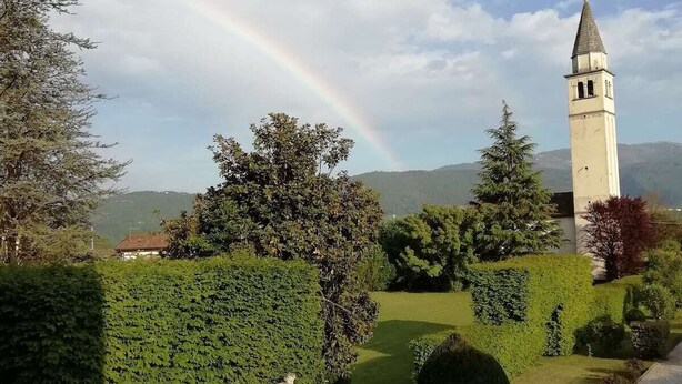 Un jardin avec une statue, une tour et un arc-en-ciel.