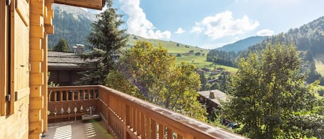 Un balcón de madera con vistas a un paisaje montañoso.