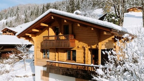 A wooden chalet with a balcony, surrounded by snow-covered trees. - 4★ Chalet, 8 pers, cozy, near slopes, La Clusaz (La Clusaz)