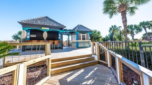 A two-story house with a blue exterior and a wooden deck. - Beach Cove Resort condo, pool & hot tub (North Myrtle Beach)