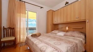 A bedroom with a bed, wooden wardrobe, and a chair. - SOLEA - 2 bedroom sea view apartment 100m from the beach in Okrug Gornji (Okrug Gornji)