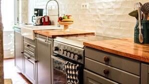 A modern kitchen with wooden beams, stainless steel appliances, and a tiled backsplash. - Loire Valley year-round country loft near Chinon (Assay)