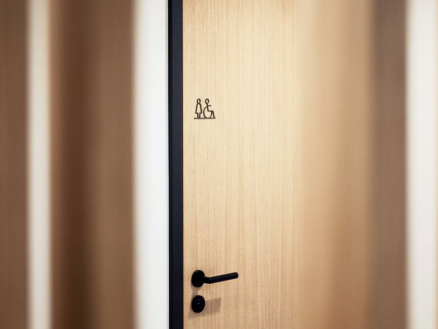 A wooden door with a black frame and a wheelchair accessibility symbol.