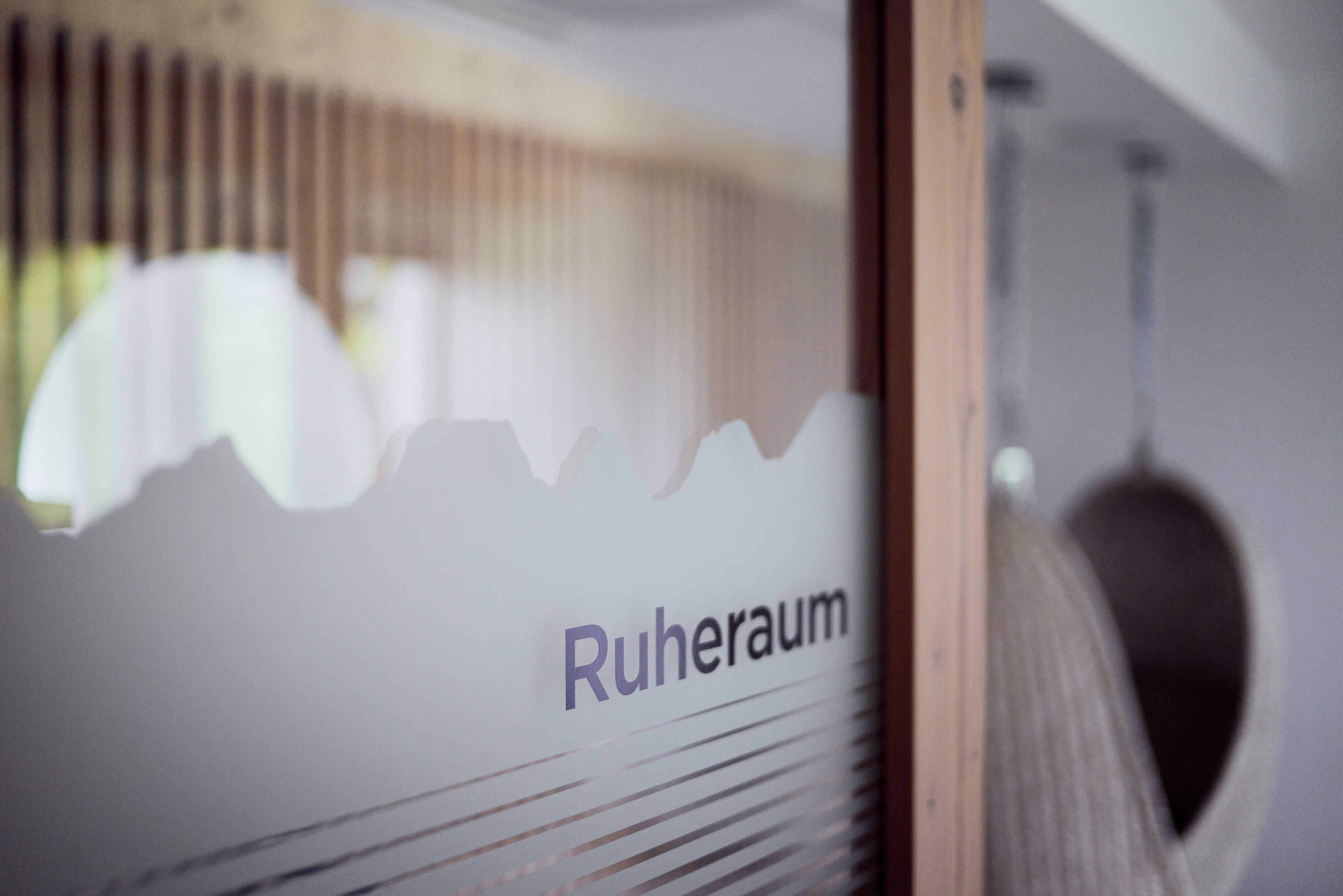 A room with a window, a bed, and a wall with the text "Ruheraum".