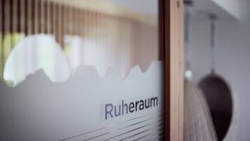 A room with a window, a bed, and a wall with the text "Ruheraum".
