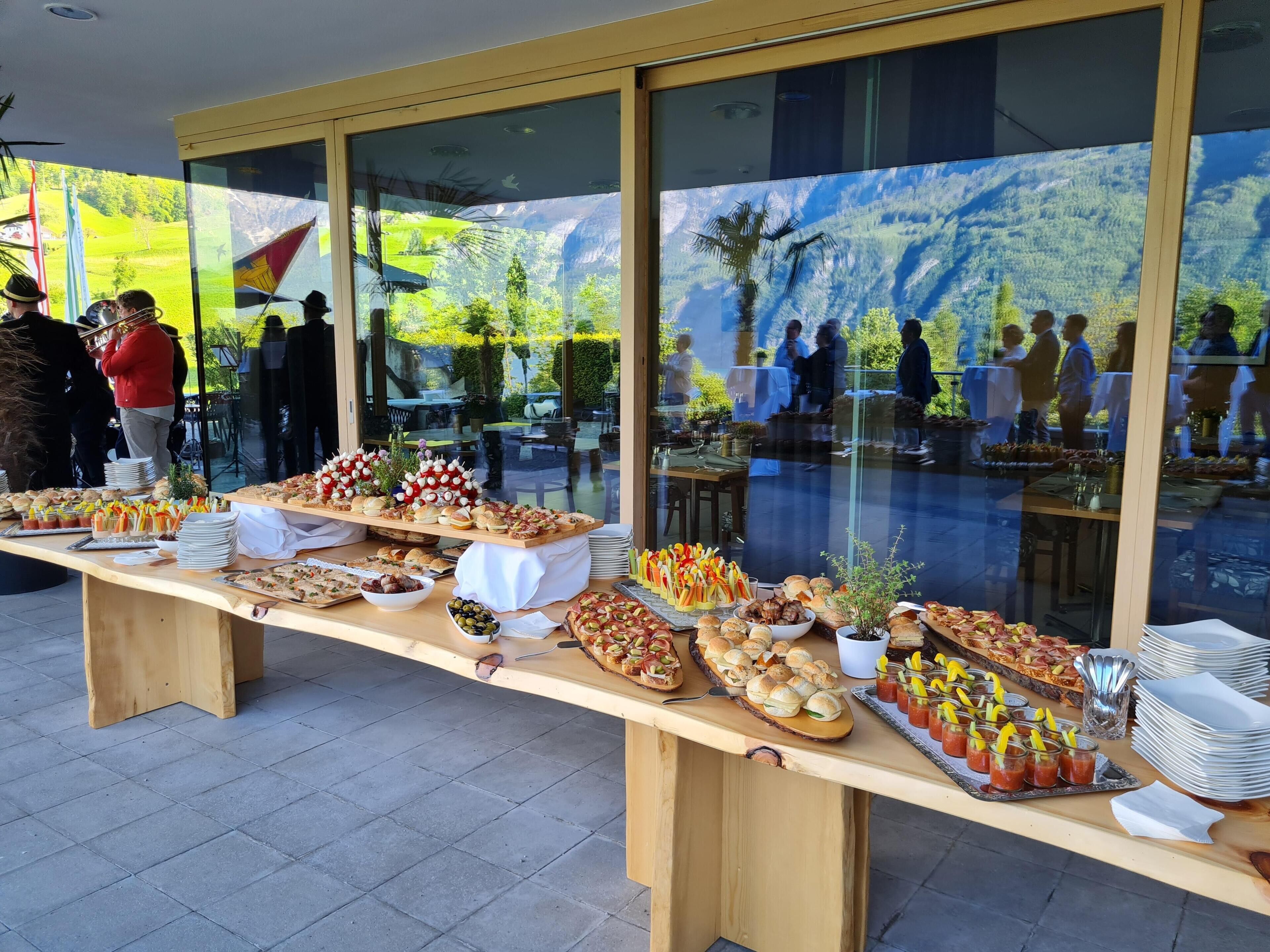 Una mesa de buffet con diferentes alimentos y un ventanal con vistas a un paisaje exterior.