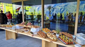 Una mesa de buffet con diferentes alimentos y un ventanal con vistas a un paisaje exterior.