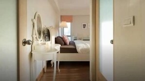 A bedroom with a bed, bedside table, and a mirror. - My Resort BKK (Bangkok)